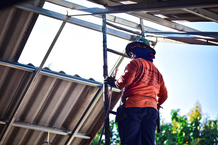 worker ladder install metal roofing