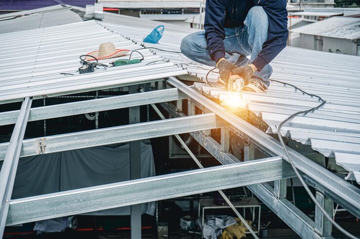 Construction worker installing metal roof