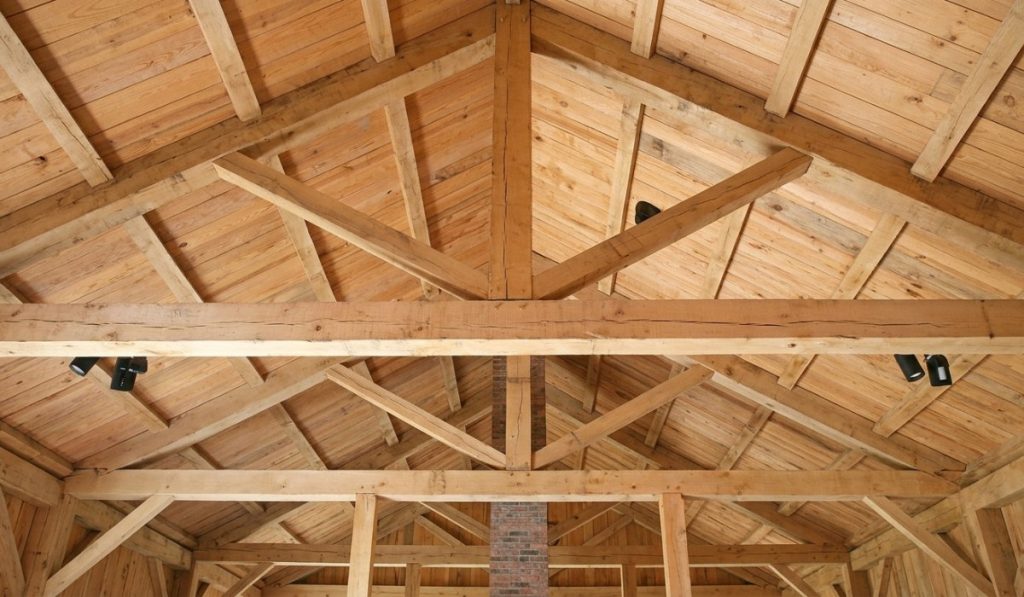 An interior view looking up at a rustic wooden ceiling with exposed timber beams
