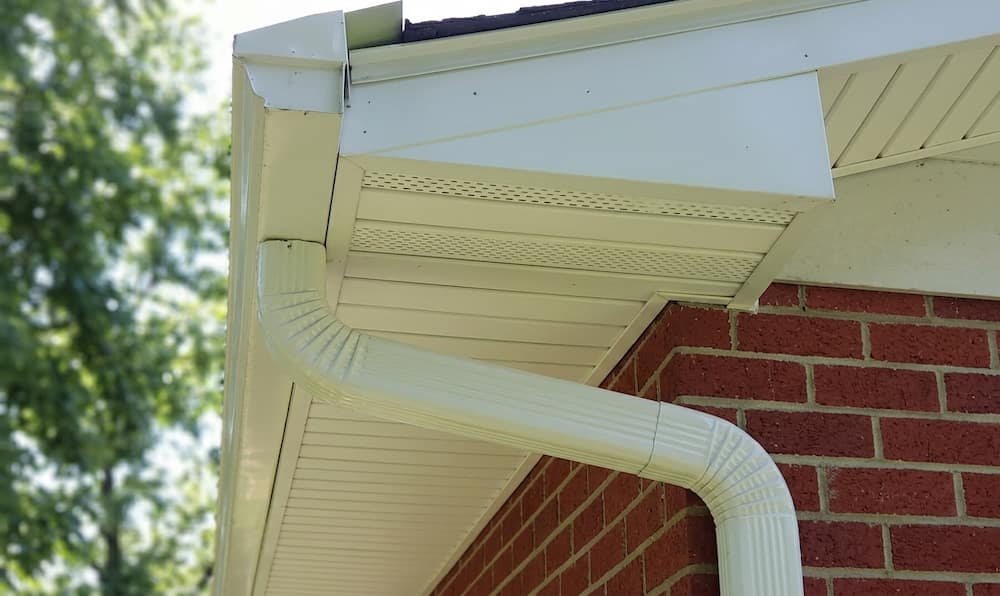 A close-up shot of a white aluminum gutter