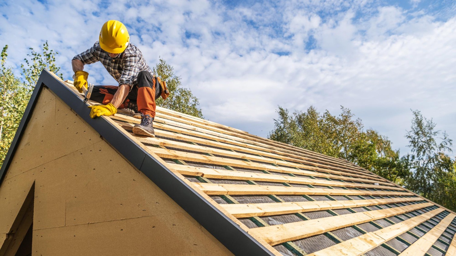 Roofer working on a pitched roof underlayment