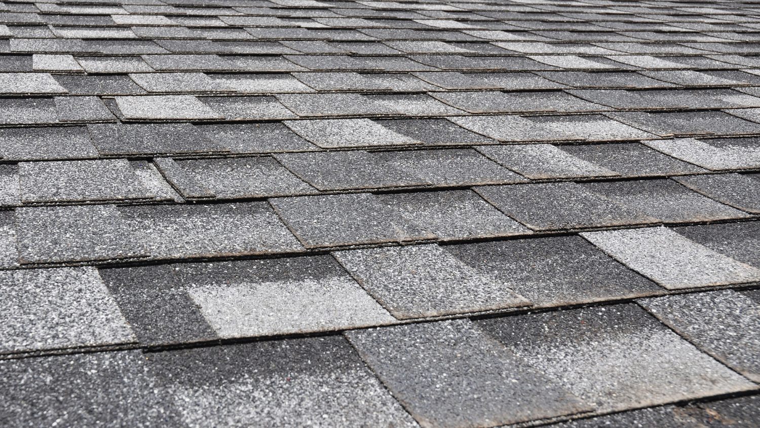 overlapping grey and black asphalt roof shingles