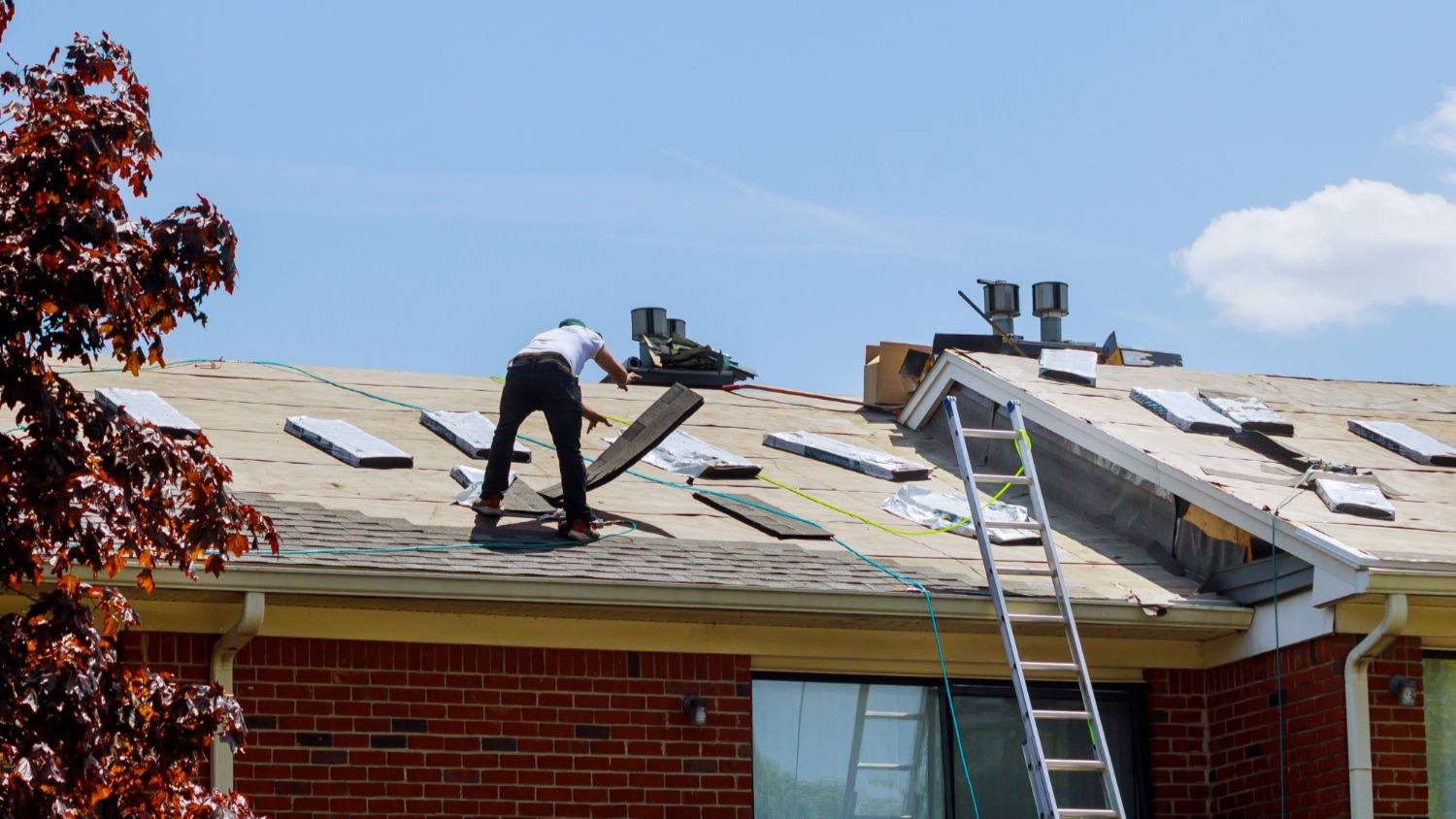 Roof replacement work on a brick home