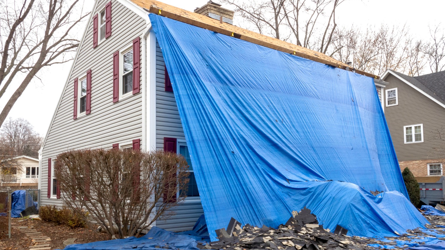 Large blue tarp covering the side and roof