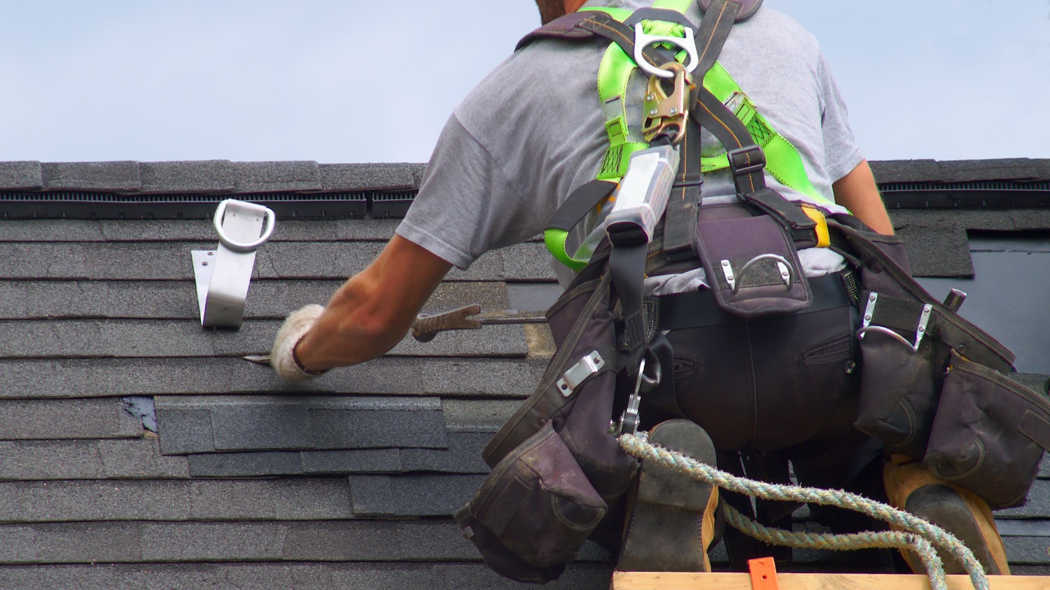 a roofer wearing a safety harness
