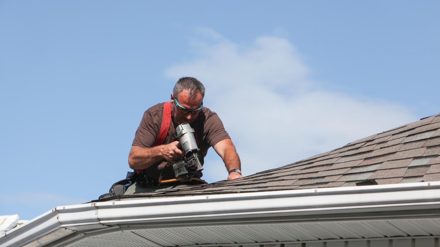 Roofer installing shingles