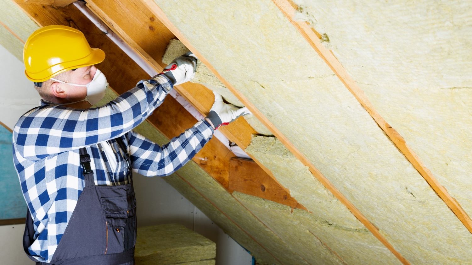 worker installing batt insulation