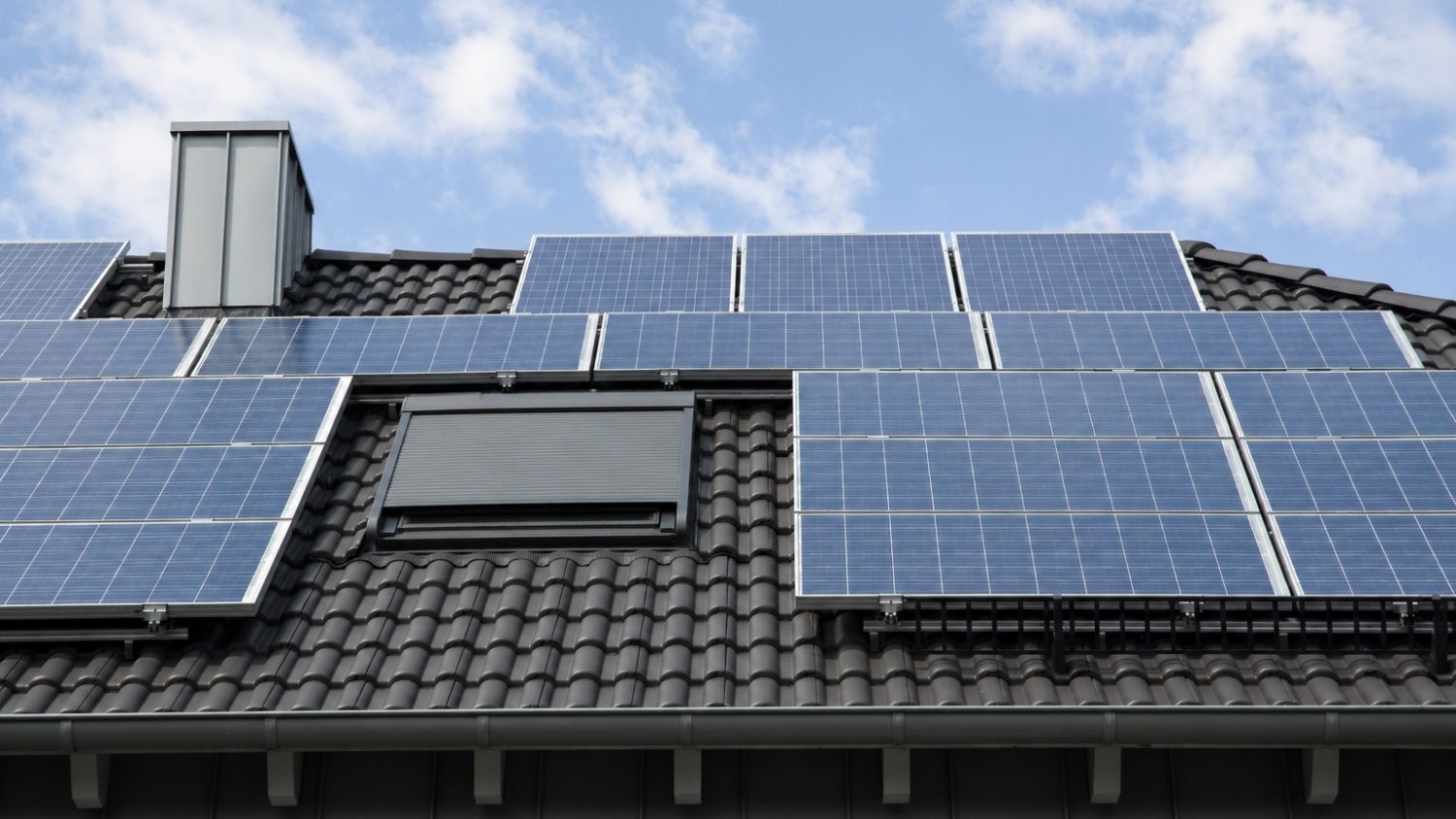 residential dark grey tiled roof outfitted with multiple grid-aligned solar panels
