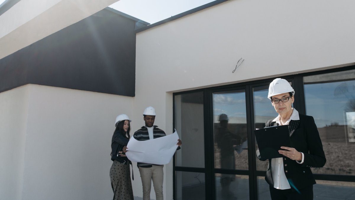 Commercial roofing professionals reviewing building plans at a modern construction site